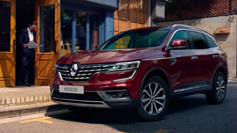 SUV Renault Koleos color vino tinto estacionada en calles de la ciudad.